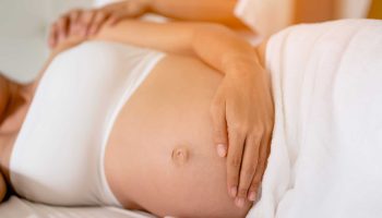 Pregnant women are enjoying a relaxing massage in bed at home. To treat and care for the mental health of the fetus Prenatal and Pregnancy Care Concept of Women